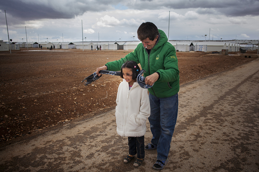 Jordan. Nine-year-old Syrian refugee, Solaf, with her father Ahmad on their way to their caravan at Azraq refugee camp