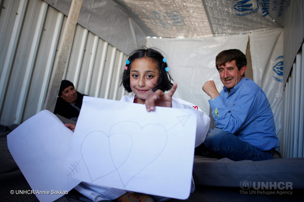 Jordan. Nine-year-old Syrian refugee, Solaf, draws with coloured pens at the caravan where she lives with her brother and parents at Azraq refugee camp
