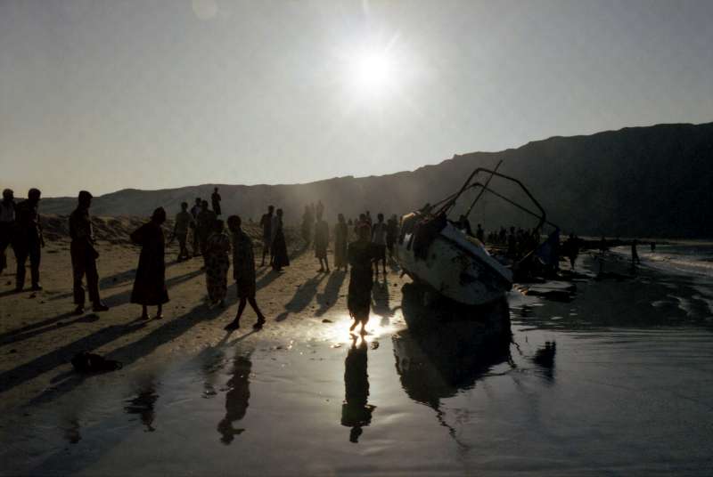 Des soldats yéménites surveillent un groupe de réfugiés éthiopiens, à côté du petit bateau de pêche sur lequel ils ont traversé le golfe d'Aden depuis la Somalie.