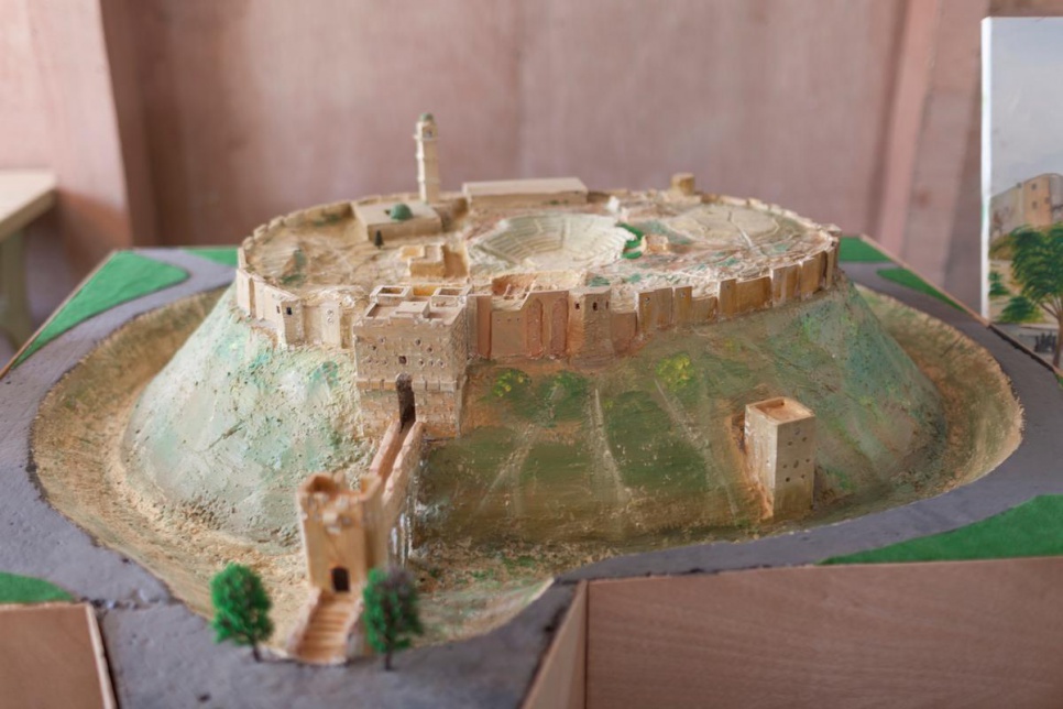 The Citadel of Aleppo is one of the miniature replicas created by the artists. The medieval structure is one of the oldest and largest castles in the world, and it towers over the old city from a strategic position atop a 40-metre-high plateau. While construction of the current fortress dates from the 12th and 13th centuries A.D., the site itself contains evidence of occupation by civilizations dating back millennia. Declared a UNESCO World Heritage Site in 1986 as part of the Ancient City of Aleppo, the citadel was placed on a list of endangered sites in 2013 as a result of the threat posed by the conflict in Syria. It has been one of the country's most popular tourist destinations, but since combatants began using the fortress as an artillery battery in 2012, it has suffered significant damage, the full extent of which is still unknown.