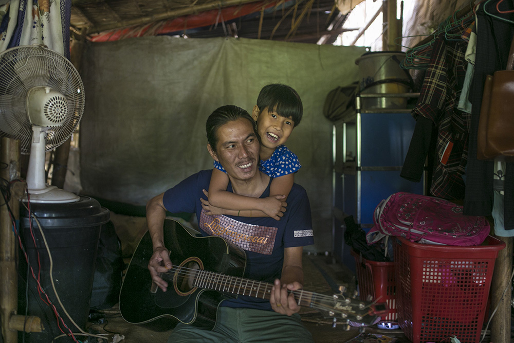 La Htaw Zau Pan plays the guitar with his daughter