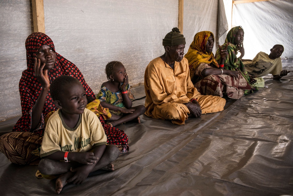 Kalthouma Abakar (left), 22, sits with her three children, her parents, her sister and her nephew, Alhaji Haoudou, in a UNHCR registration tent at Dar-es-Salam settlement in Chad.