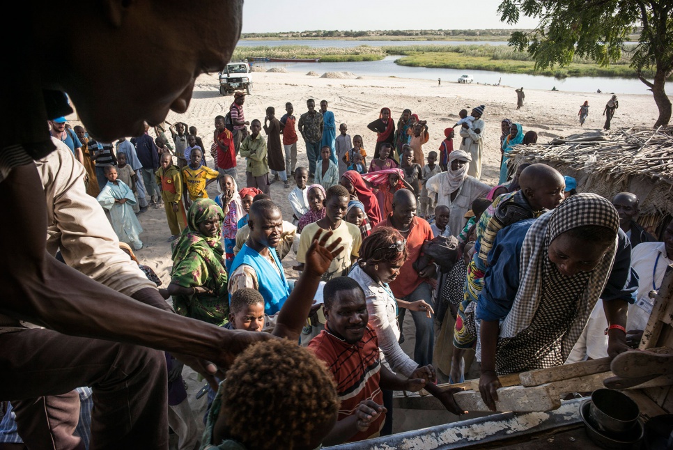 Nigerian refugees board a UNHCR truck on the beach of Baga Sola, Chad. They are being voluntarily transferred to the Dar-es-Salam site, 12 kilometres away.