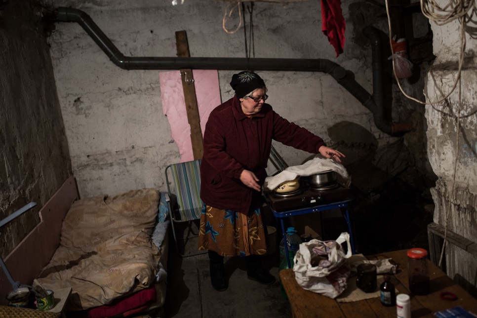 Liuba, 60, covers pots of food on a stove in a basement in the Kievsky district of Donetsk, Ukraine. "The ambulance has come four times for me, but I always come back."