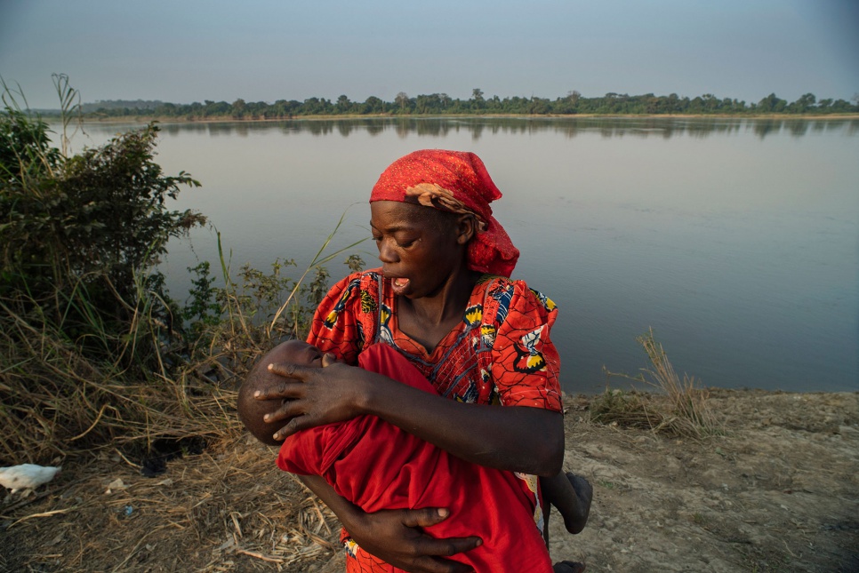 Ifara Antoinette, 41, comforts her son, Gonda Ismael, two, on the banks of the Oubangui River after his examination by a UNHCR/WFP nutrition team at the Akoya site in DRC.