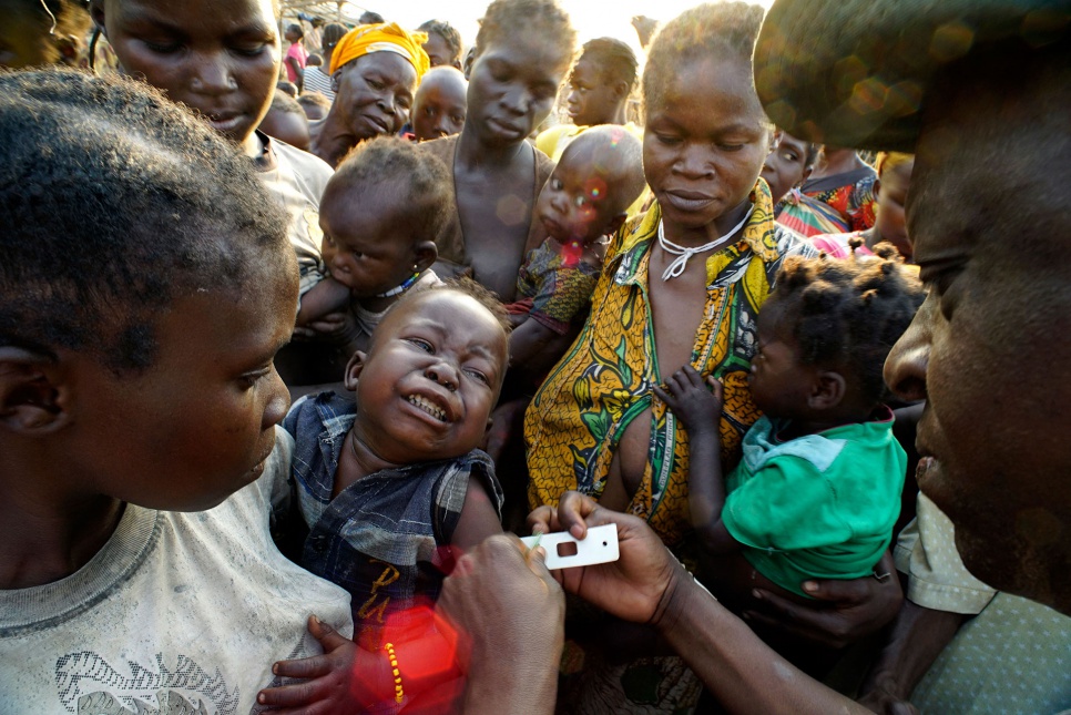 A nutrition expert checks newly arrived refugee children for signs of malnutrition at the Akoya spontaneous site on the banks of the Oubangui River in DRC's Equateur Province.