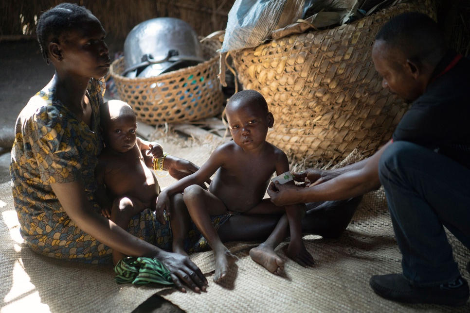 A member of the UNHCR/WFP nutrition team checks two-year-old Philomène, a newly arrived refugee from CAR, for signs of malnutrition at the Gbadakila site in DRC's Equateur Province.