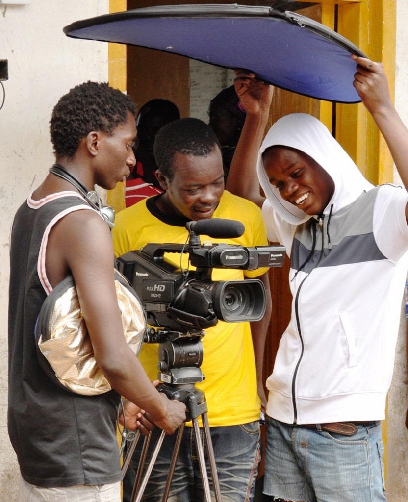 Imani (centre) one of the group’s cameramen with the soundman and light man on the set of the movie shoot.