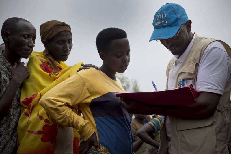 UNHCR staff member Paul Kenya registers refugees from Burundi as they board a bus to take them to the new Mahama refugee camp  in the Bugesera Reception Centre in Rwanda in May.