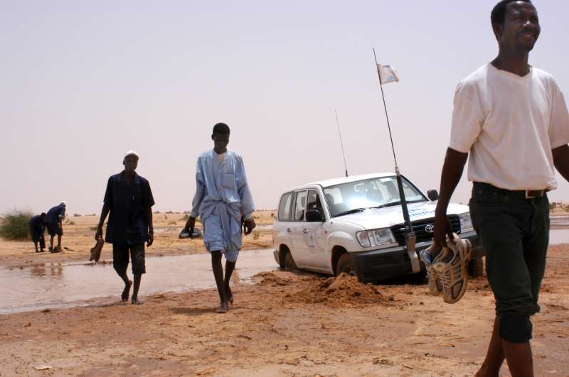 UNHCR and Red Cross workers continue by foot across the seasonal riverbed where a UNHCR vehicle got stuck. It took four hours for two cars and a truck to liberate the trapped vehicle. (July 16, 2004)