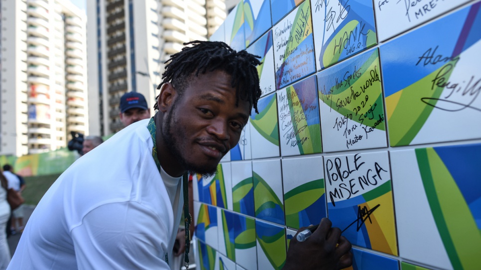 Popole Misenga from Congo signs the Olympic Truce Wall in Rio's Olympic Village.