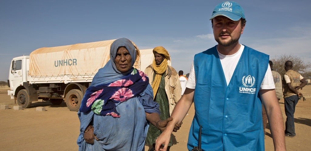 UNHCR aid worker Hugo Reichenberger helps an old Malian refugee woman to settle in Goudebou camp where she has just arrived. 