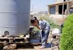  آية تغسل وجهها بالماء من خزان كبير خارج منزل أسرتها. تتوفر مياه الشرب للاجئين عن طريق مصدر محلي للمياه.