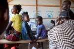 جوا وماريا (إلى اليمين) ينتظران مع بعض أطفالهما للحصول على استمارات العودة الطوعية في كيمبيسي قبل يوم من عودتهم إلى أنغولا. 