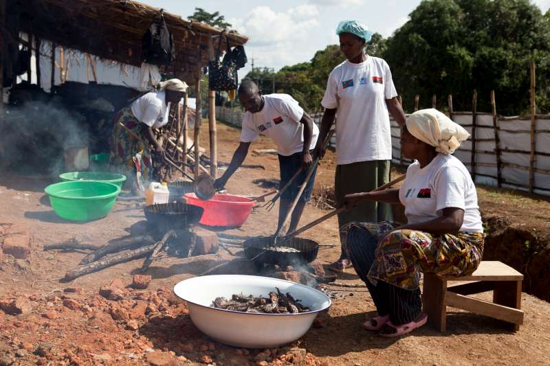 سيدات أنغوليات لاجئات يقمن بإعداد العشاء في مخيم عبور كيمبيسي قبل يوم من مغادرتهم إلى الحدود والعودة إلى الوطن.