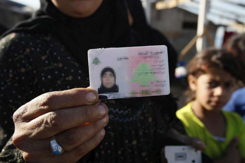 إمرأة من شمال لبنان تمسك بوثيقة الجنسية. زوجها من عديمي الجنسية ولم يتمكن أطفالها من اكتساب الجنسية اللبنانية لعدم قدرة النساء من منح جنسياتهن لأطفالهن.