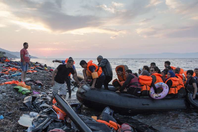 Au coucher du soleil, un groupe de réfugiés, Syriens pour la plupart, arrive sur l'île grecque de Lesbos après avoir traversé la mer Égée à partir de la Turquie.