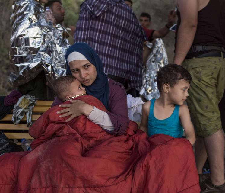 
Une réfugiée syrienne, Asmaa, berce son bébé de six mois, Osman; son fils Abdul Rahman, âgé de cinq ans, est à ses côtés. Asmaa et son mari, Omar, ont fui leur maison près de Damas il y a six semaines, voyageant à travers le Liban et la Turquie avant de traverser la mer Égée en direction de la Grèce. L'embarcation bondée a commencé à prendre l'eau lorsque son moteur a lâché. Cherchant désespérément à rester à flot, les passagers ont jeté leurs bagages par-dessus bord. La famille d'Asmaa a tout perdu, y compris les passeports et le peu d'argent liquide qu'elle avait.