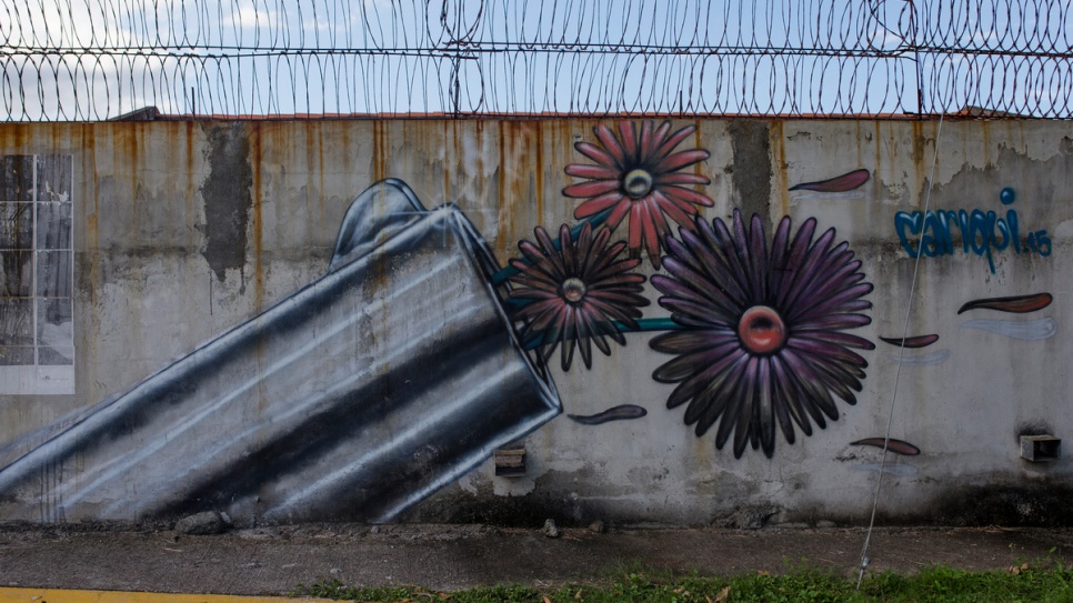 A mural in San Pedro Sula shows flowers emerging from a gun barrel. In 2014, the gang-ravaged city had the highest murder rate in the world.