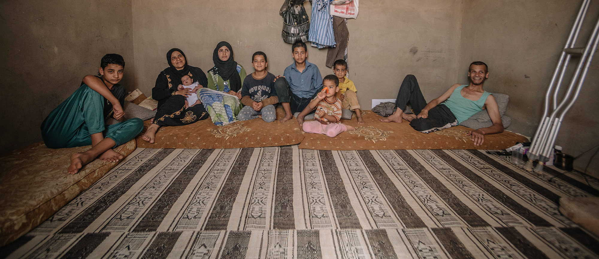 For large Syrian families, the spaces that they share often mean living in very close proximity to one another.In a former chicken barn in Mafraq, Jordan a collection of Syrian families have taken up residence.Although the building is old and the converted apartments basic, still each family must pay monthly around $250. The bathrooms and kitchens abbut one another and many people share the same sleeping rooms. / UNHCR / J. Kohler / August 2014