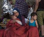 
Une réfugiée syrienne, Asmaa, berce son bébé de six mois, Osman; son fils Abdul Rahman, âgé de cinq ans, est à ses côtés. Asmaa et son mari, Omar, ont fui leur maison près de Damas il y a six semaines, voyageant à travers le Liban et la Turquie avant de traverser la mer Égée en direction de la Grèce. L'embarcation bondée a commencé à prendre l'eau lorsque son moteur a lâché. Cherchant désespérément à rester à flot, les passagers ont jeté leurs bagages par-dessus bord. La famille d'Asmaa a tout perdu, y compris les passeports et le peu d'argent liquide qu'elle avait.