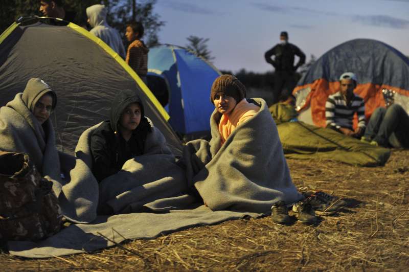À la nuit tombante, des réfugiés campent dans le froid à l'extérieur du centre d'enregistrement surpeuplé de Röszke, en Hongrie, près de la frontière serbe. 