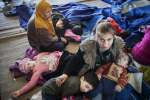 أم سورية تجلس على متن السفينة الإيطالية "فيرغا" مع أطفالها الصغار. وقد تم إنقاذهم من قارب صيد يحمل 219 شخصاً في محاولة لعبور البحر المتوسط من ليبيا.