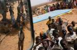 Refugee children at Touloum camp wait for the water bladder to be filled. Every day, water is trucked to the camp to meet the needs of the refugees, while aid agencies continue to drill in search of new water sources at the camp itself. (April 24, 2004)