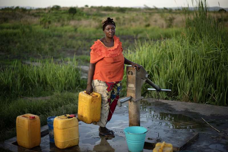 Okenge Sakina vient collecter de l'eau au puits de Lukwangulo, RDC. HCR/Brian Sokol