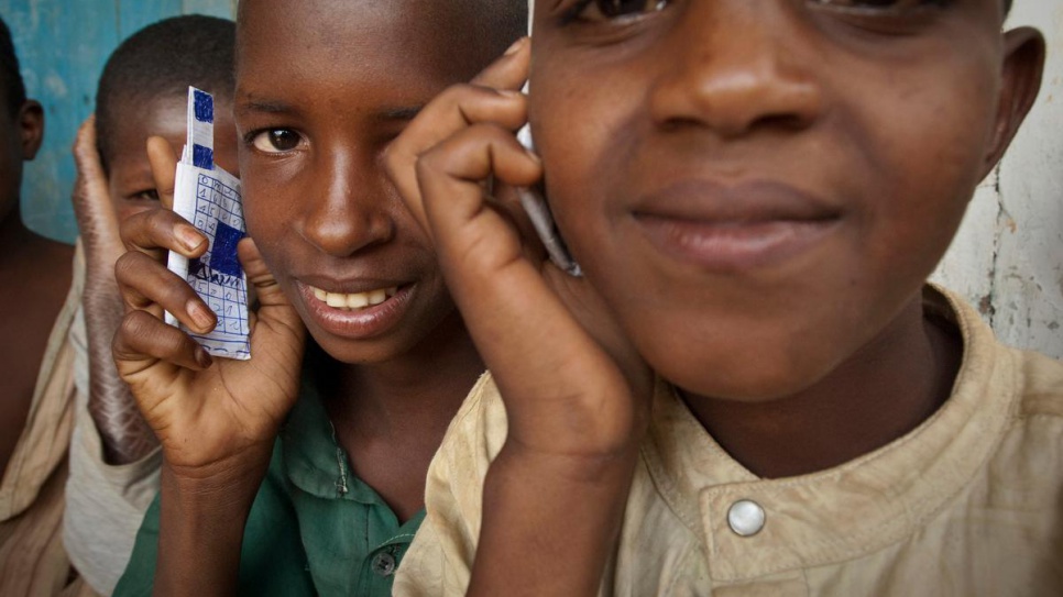 Children at a school in Gbiti, Cameroon, play with cellular phones that they drew, in this 2009 file photo.