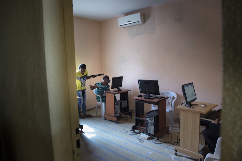 Budiaki helps a student with her keyboard during a basic computer skills training session at Nouakchott's Women's Centre.