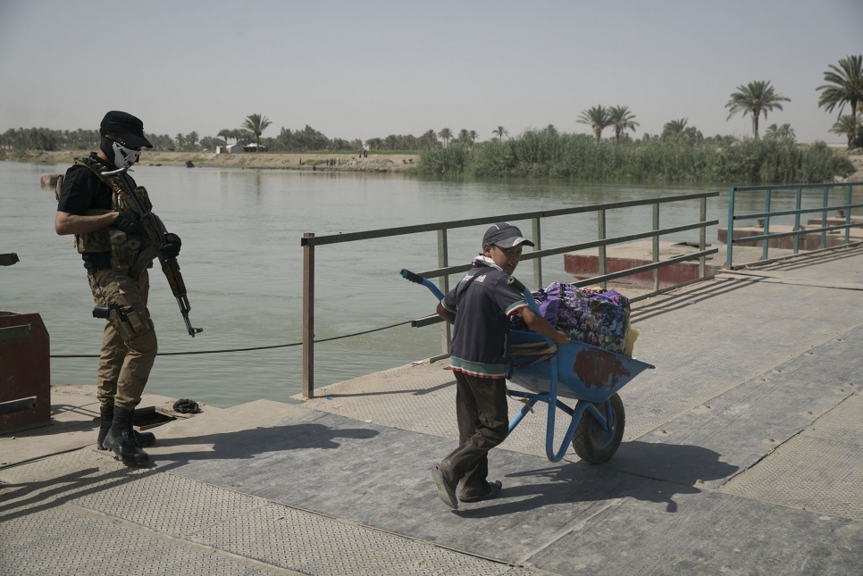 A child carts belongings across the Bzeibiz bridge, which connects Anbar and Baghdad Provinces.