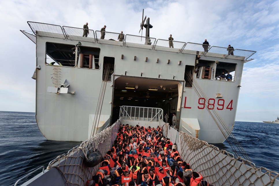 An Italian Navy vessel rescues 186 refugees and migrants crossing the Mediterranean on a smuggler's boat in March 2014. Desperation is driving more and more people to risk their lives at sea.