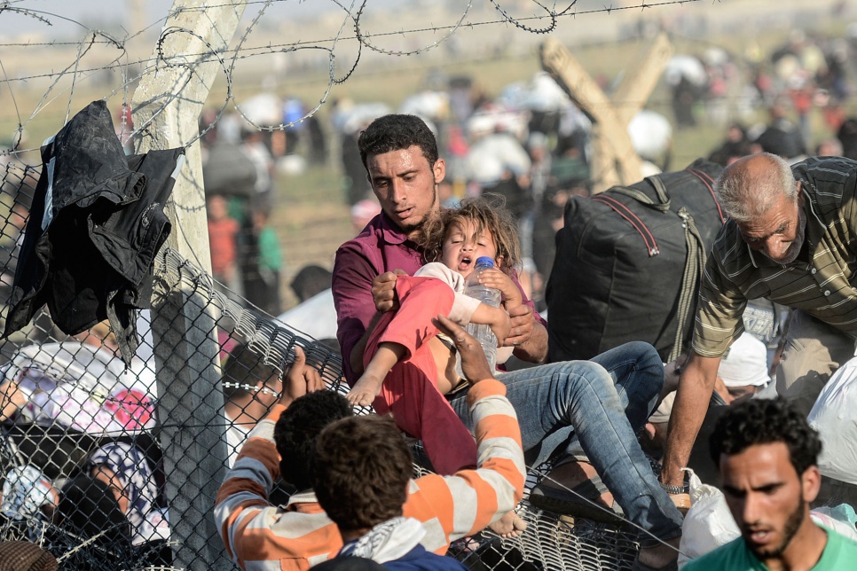 Thousands of Syrian refugees cross the border into Turkey after fresh fighting in June 2015.