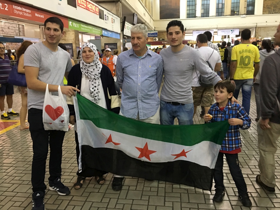 Une famille syrienne réfugiée se rassemble pour soutenir l'équipe des réfugiés. 