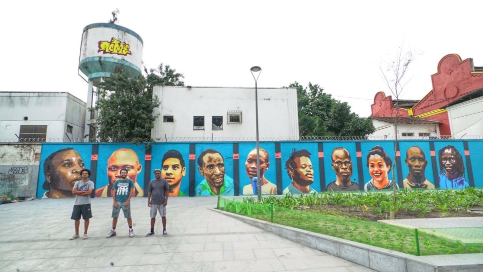 Des artistes des rues de Rio devant la fresque murale qu'ils ont créée pour célébrer la première Equipe olympique de réfugiés de l'histoire. 