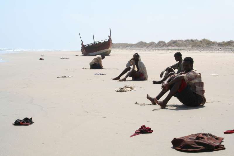 Epuisés par leur voyage, des survivants de la traversée du Golfe d'Aden attendent de l'aide sur une plage du Yémen. Depuis le début de 2007 jusqu'à la fin mars, plus de 100 morts ont été comptabilisés parmi les victimes des trafiquants. 