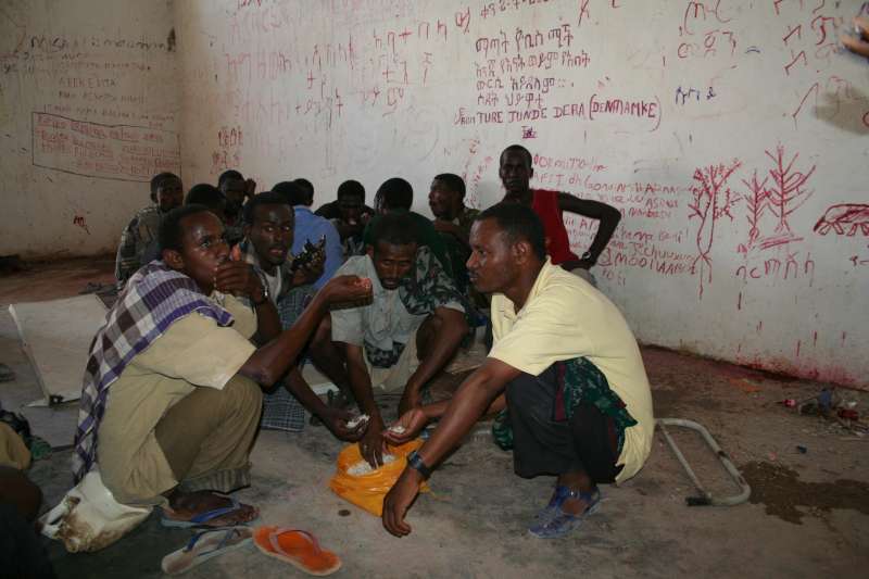 Des réfugiés et des migrants somaliens et éthiopiens attendent dans une pièce du centre de détention d'Obock.