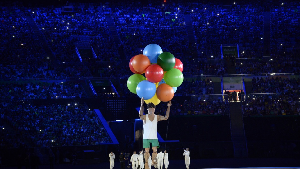 Des marionnettistes dirigent un personnage géant à la cérémonie d'ouverture des jeux paralympiques 2016 de Rio de Janeiro.