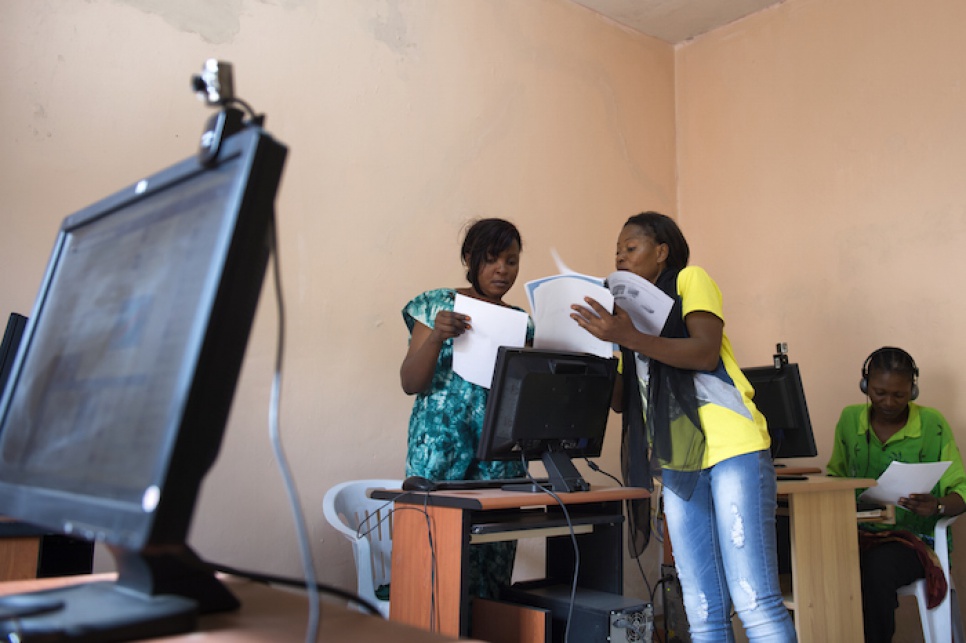 Budiaki runs through her information technology manual with a student during basic computer skills training.