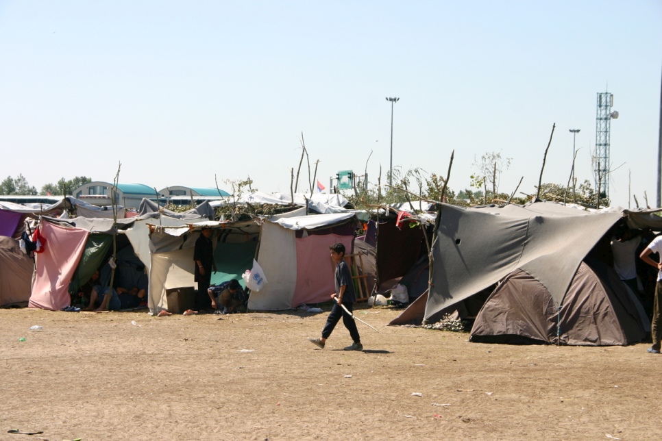 Un jeune garçon passe devant quelques-unes des tentes érigées à la hâte où s'abritent les réfugiés en attendant de passer en Hongrie. 