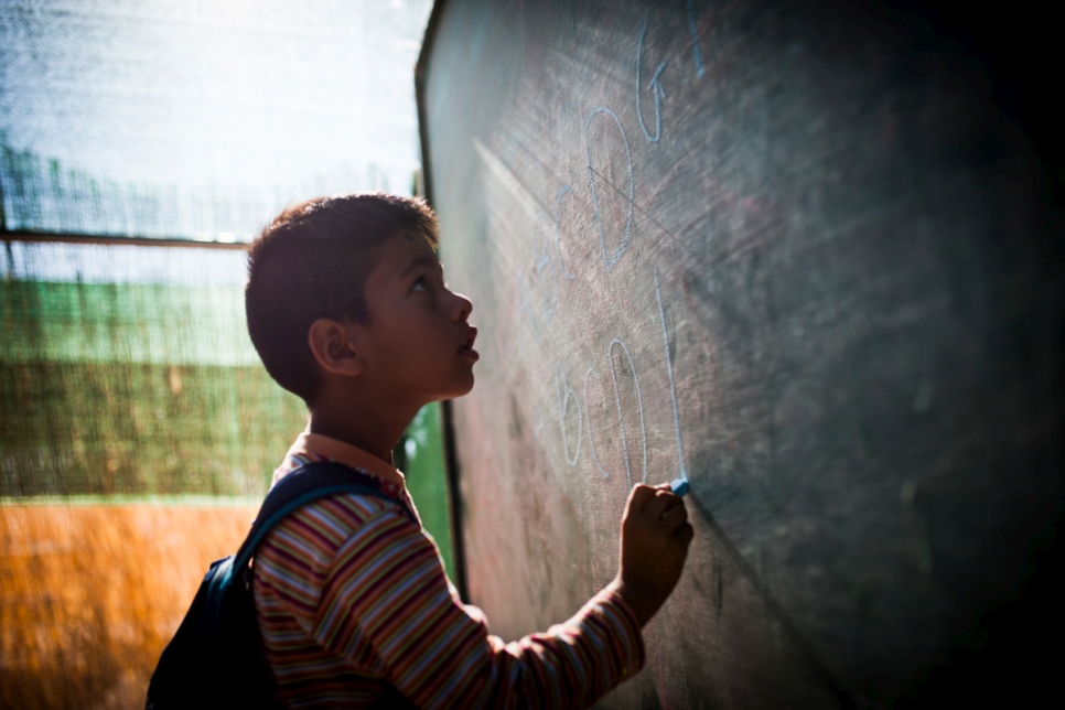 An Afghan boy spells out the Roman alphabet at a special English-language class at the Oinofyta reception centre in Greece.