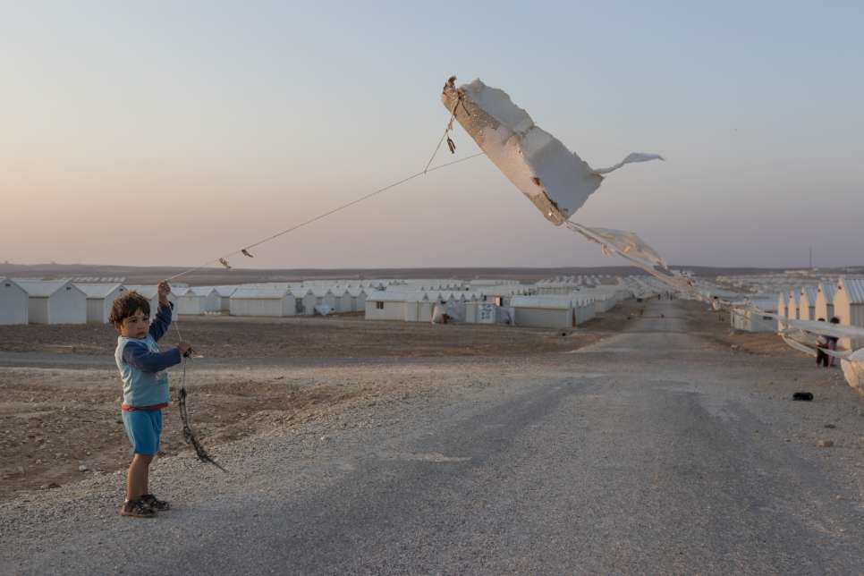 Un jeune Syrien fait voler un cerf-volant fabriqué à partir d'un morceau d'isolant au camp de réfugiés d'Azraq en Jordanie.