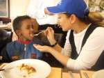 Goodwill Ambassador Muazzez Ersoy feeds a young boy at a lunch she hosted for refugee families in the Turkish capital, Ankara.