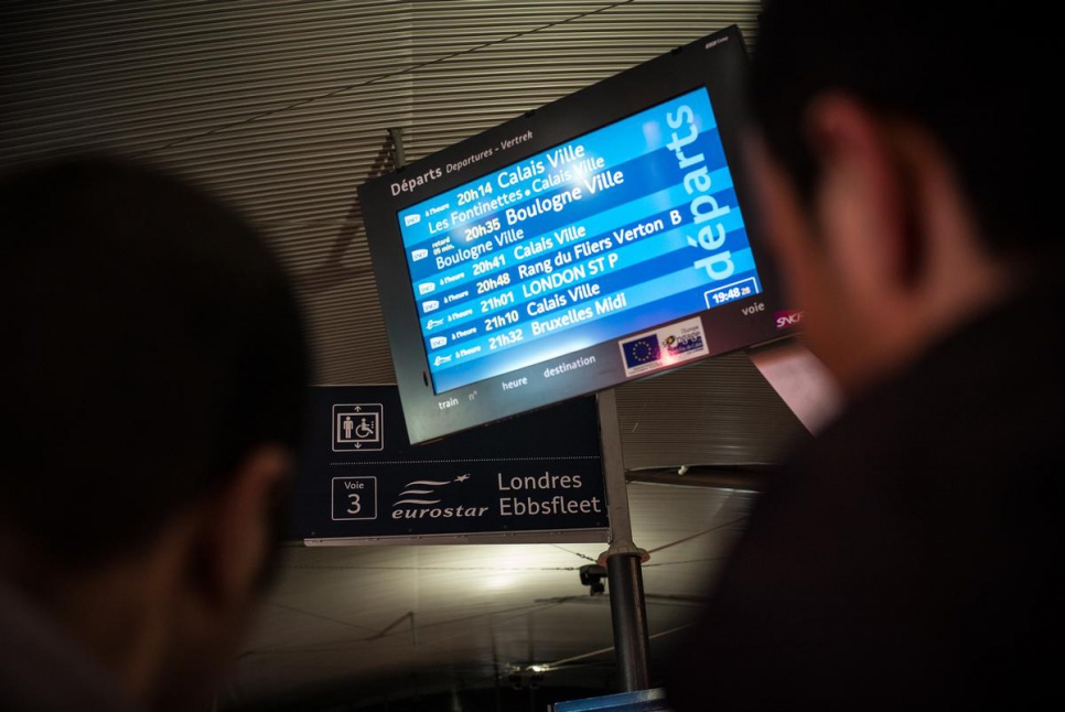 The Syrians check the train timetable in Calais. "I left Syria because the life is so difficult there," says Ahmed. "There is a war... That's the reason why I am leaving to Britain."