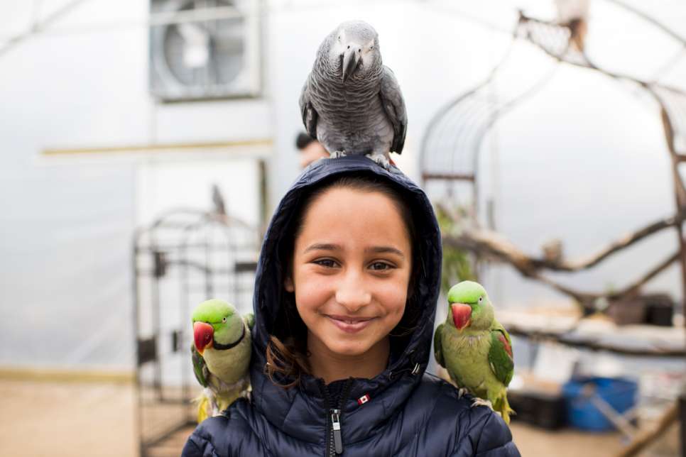 Hadil poses with birds on her head and shoulders during a visit to the petting zoo.