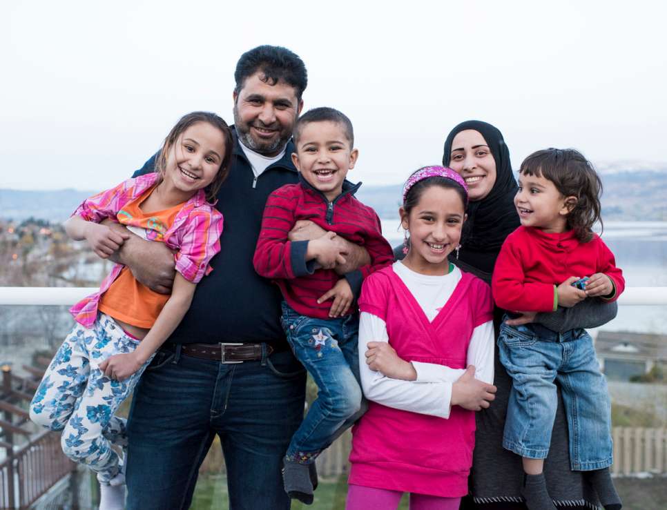 Mohammad and Sahar pose with their children on the balcony of the house their Canadian sponsors have rented for them.