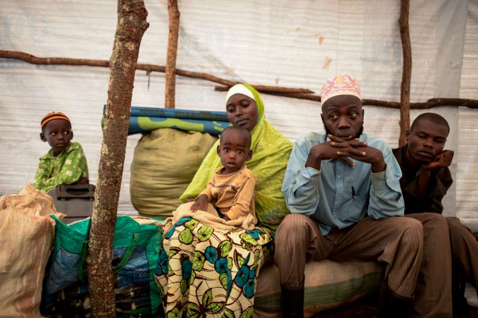 Abdul Yamuremye, 32, sits with his wife, Hadija Umugure, 25, their two children and their cousin, Abdalla Nitereka, 20 (on right). They fled violence in Burundi.