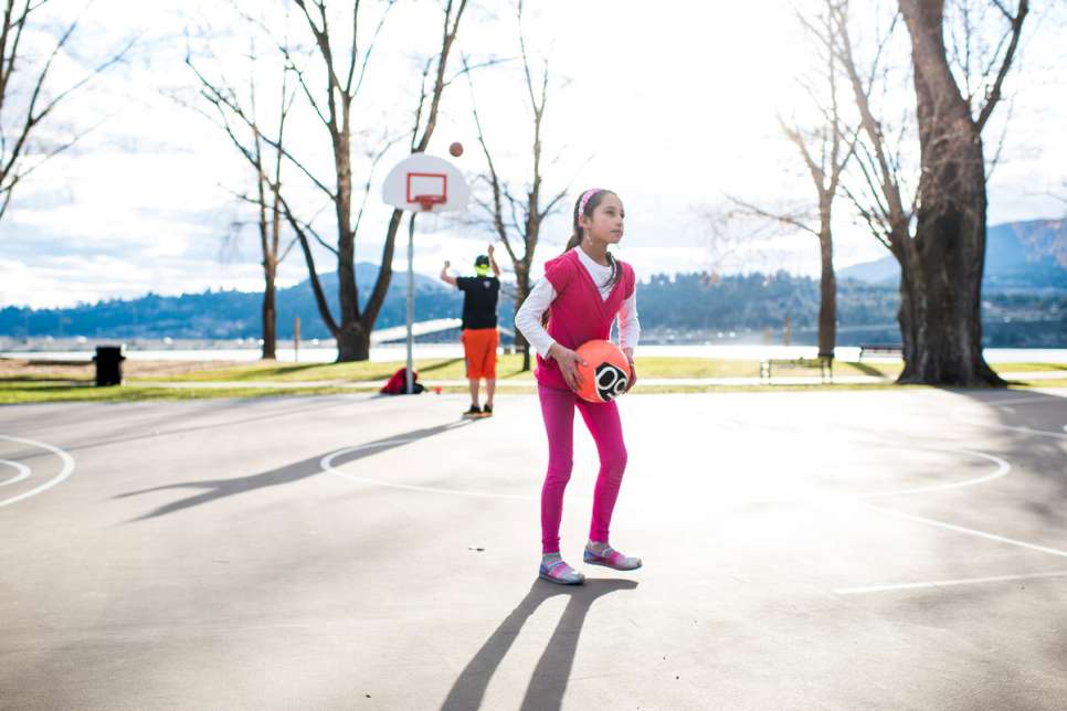 Hadil, a Syrian refugee resettled to Canada, learns to play basketball during an outing organized by her sponsors.