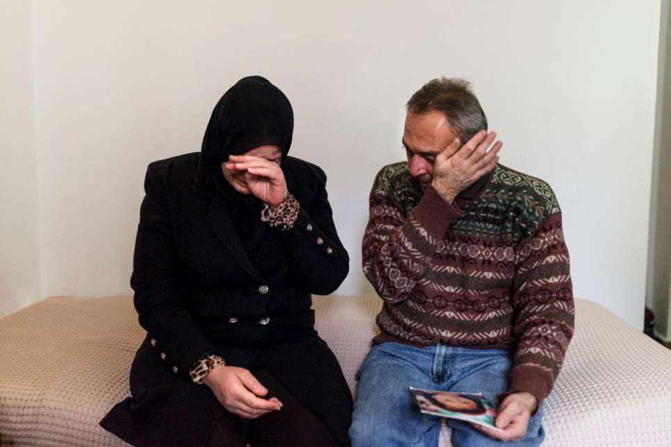 Mahmoud and Reem Al-Hayek cry while holding a picture of their 6-year-old daughter, Rand, who died shortly after the family crossed the Greek border.